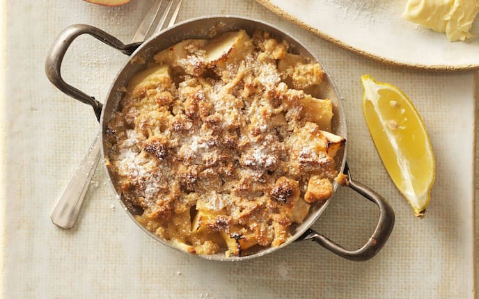 Apfelstreusel in einer Pfanne mit Staubzucker bestreut