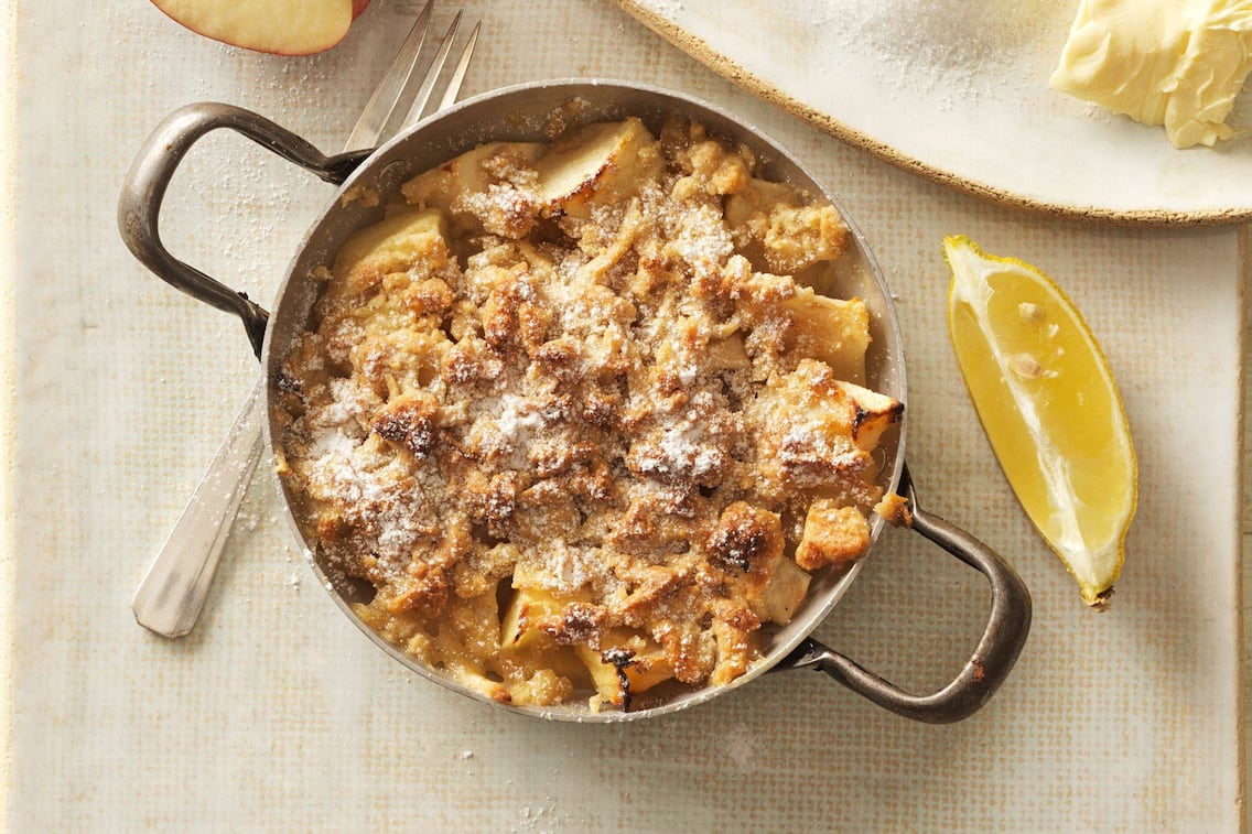 Apfelstreusel in einer Pfanne mit Staubzucker bestreut