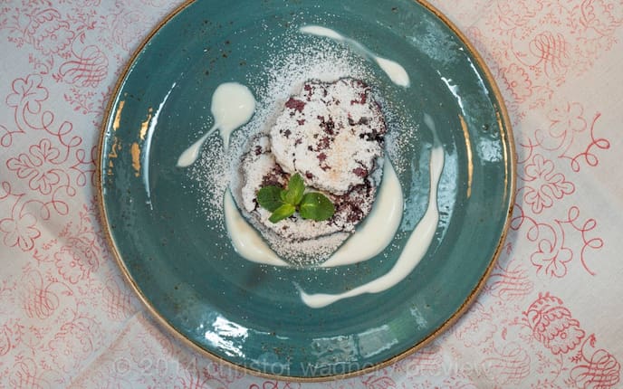 Mossbeeren, Heidelbeeren, Minzeblätter, Nocken, Staubzucker, Teller