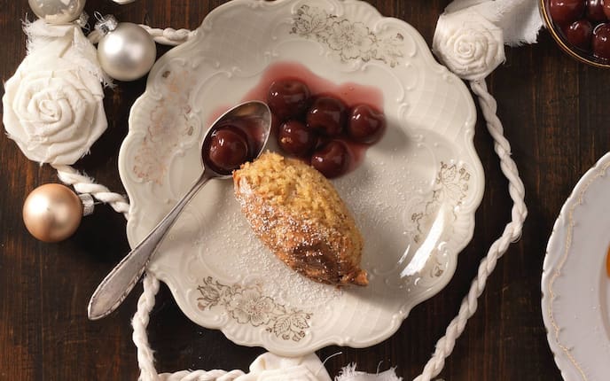 Nussauflauf, Staubzucker, Kirschkompott, Löffel, Teller