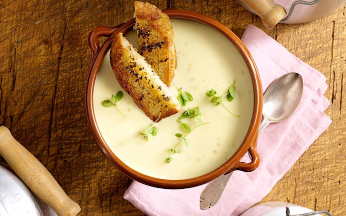 Käsesuppe mit Gewürzbrot, Majoran, Kümmel, Suppentopf, Suppenlöffel, Holztisch, Milchkanne, Serviette