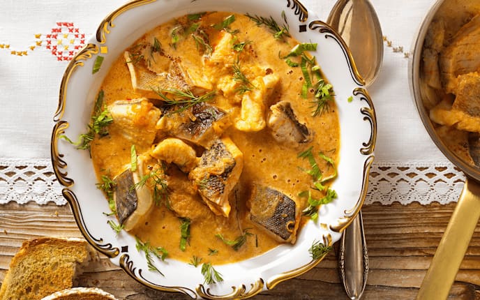 Würzige Fischsuppe, Brot, Tischdecke, Holztisch, Löffel, Selleriegrün, Dille