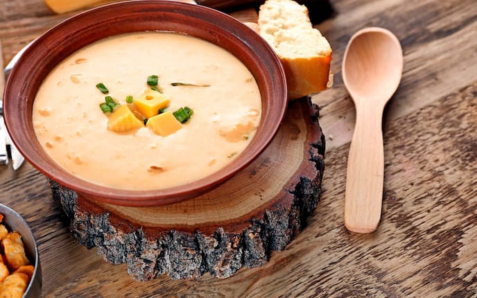 Almkäse, Schnittlauch, Holzbrett, Suppenteller, Holzlöffel, Suppe, Messer