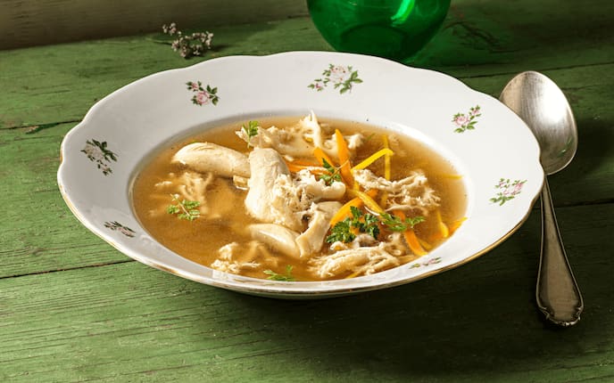 Hendlsuppe mit Pilzen, Kräuter, Karotten, Suppenteller, Vase, Holztisch