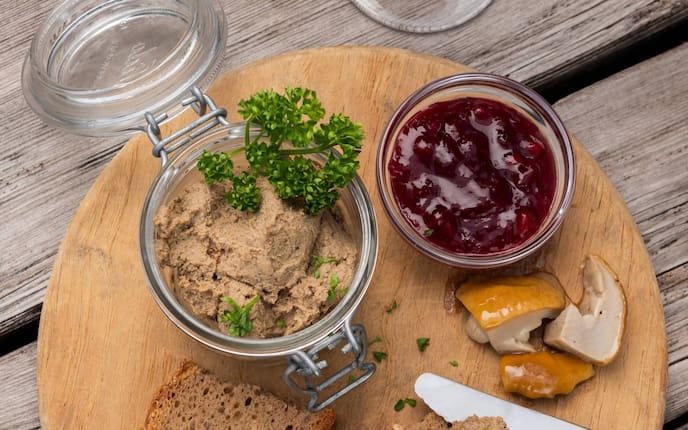 Leberpastete, Lammleberpastete, Petersilie, Preiselbeeren, Brot, Messer, Holzbrett
